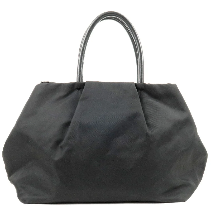 Prada bags with a snap - button closure and a decorative charm for a fashionable lookPrada bags with a snap - button closure and a decorative charm for a fashionable lookPRADA Logo Nylon Leather Ribbon Tote Bag NERO Black BN1601